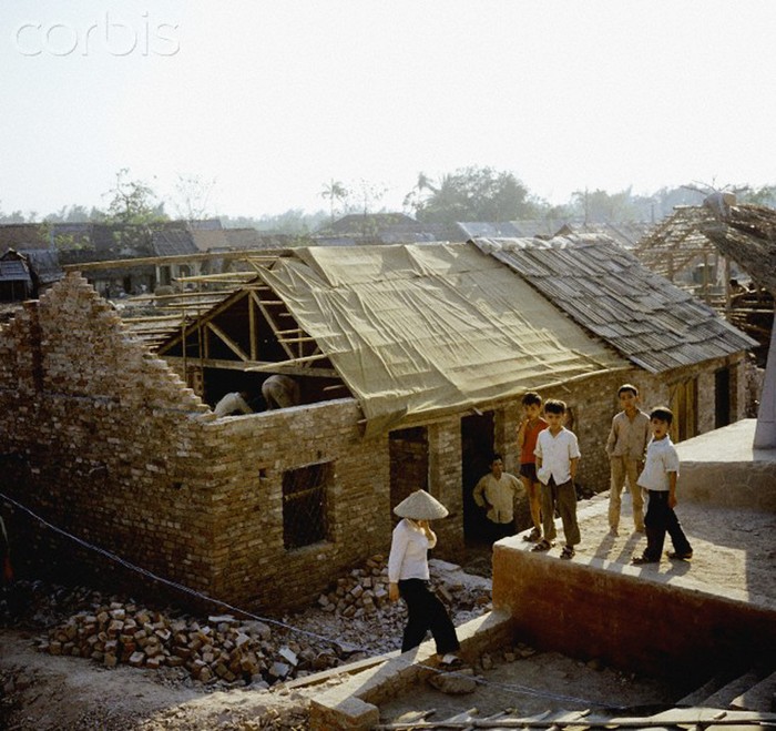 Bọn trẻ bên cạnh một ngôi nhà đang được xây lại tại khu phố Khâm Thiên sau trận bom của máy bay B52 của quân Mỹ tháng 12/1972. Ảnh. © Werner Schulze-dpa-Corbis.